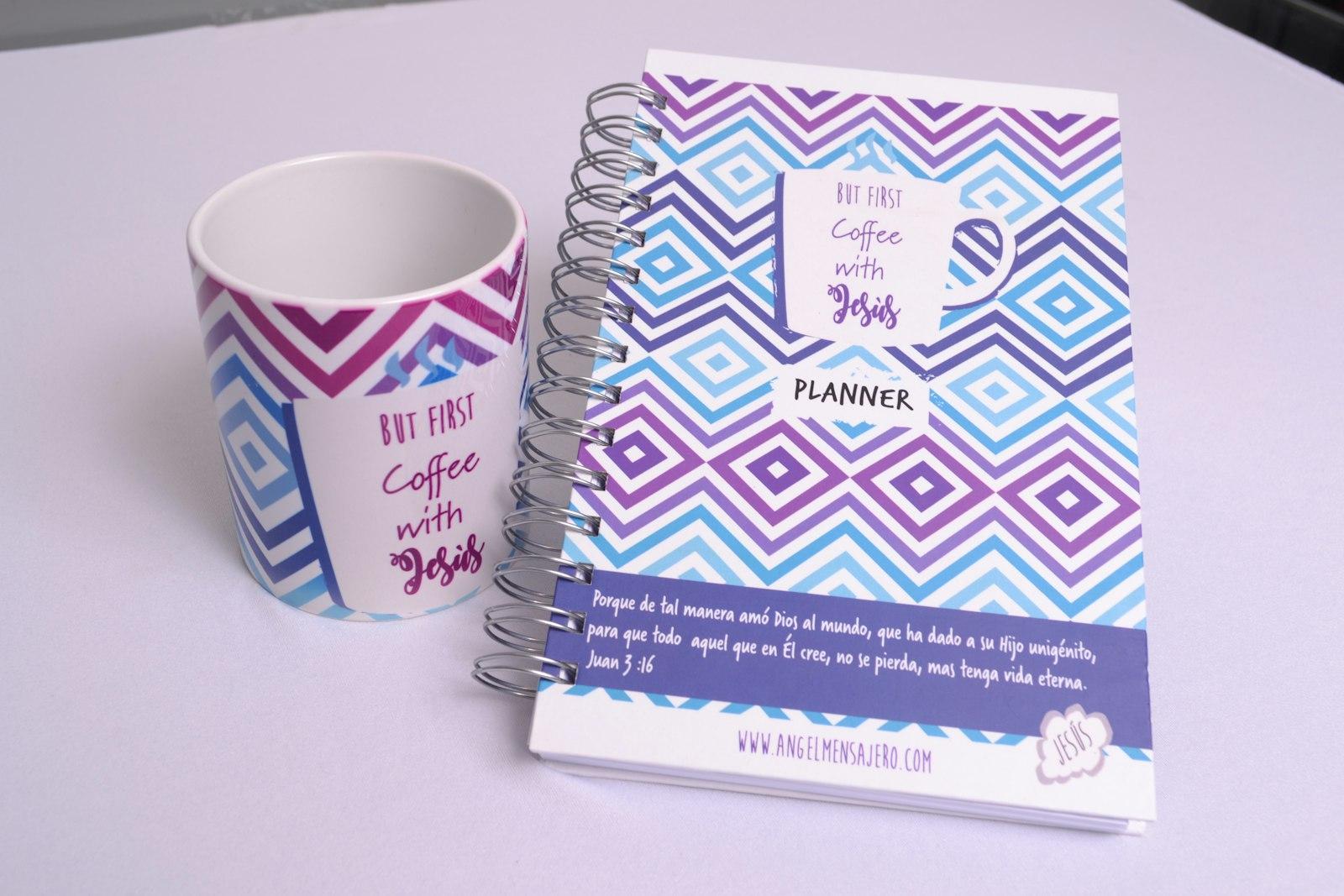 Une tasse de café posée près d’un agenda sur une table