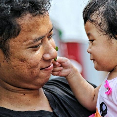 A father holding his young daughter