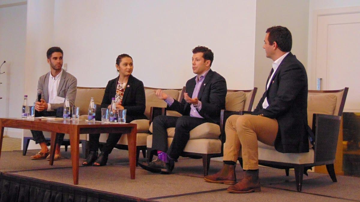 Eric Kryski on a panel in Bermuda, mid-answer, beside three other speakers.